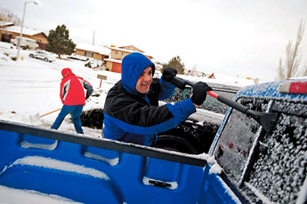 Chris Chamberlin scrapes ice from his windshield as his wife Pearl shovels snow in their driveway on Anthony Avenue on Tuesday morning. &mdash;&nbsp;&copy; 2009 Gallup Independent / Brian Leddy 
