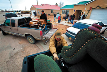 Delbert Gordon readjusts his daughter's couch while her family is being evicted Monday from their Churchrock Estates home in Churchrock. &mdash;&nbsp;&copy; 2009 Gallup Independent / Diego James Robles